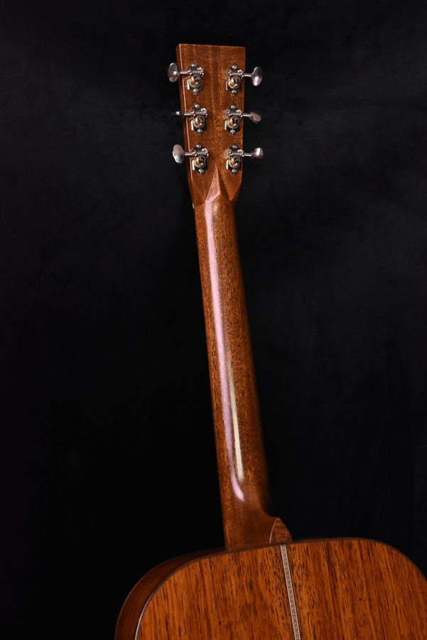 Acoustic guitar headstock with six tuning pegs and natural wood finish