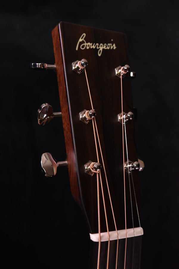 Bourgeois acoustic guitar headstock with tuning pegs and cursive logo.