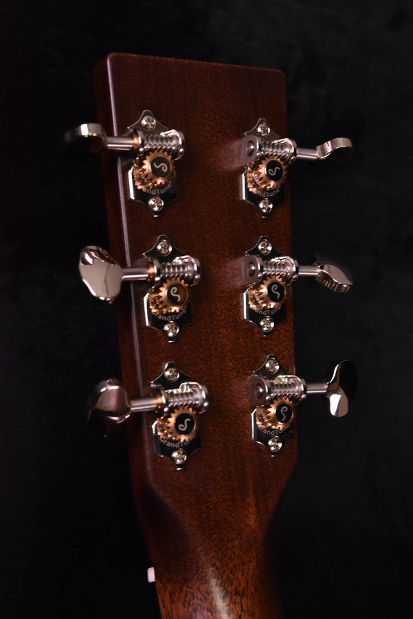 Guitar headstock close-up with tuning keys and metal plates