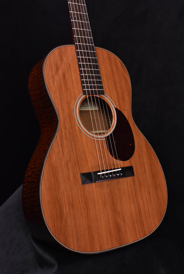 Acoustic guitar body close view, natural top wood, black pickguard and bridge
