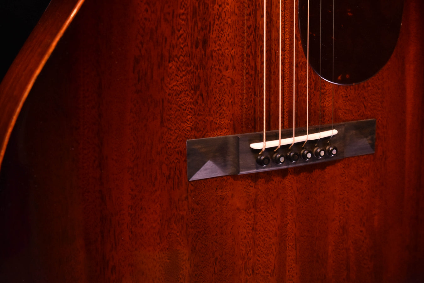 Sunburst acoustic guitar close-up of strings and dark bridge