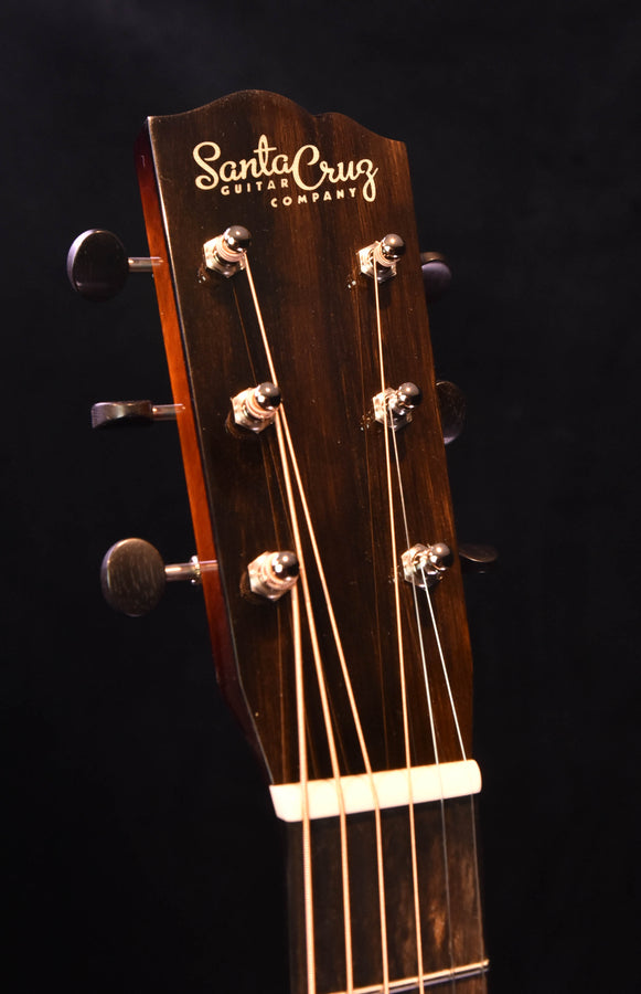 Guitar headstock with tuning pegs and Santa Cruz logo, vertical close-up