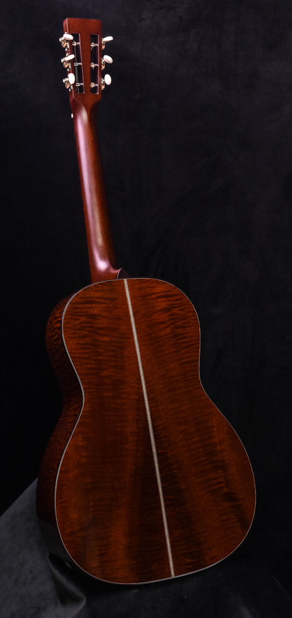 Acoustic guitar back view, quilted dark wood with border trim and sound hole rosette edge