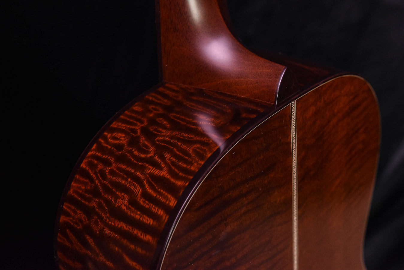 Acoustic guitar body top with quilted grain and side binding, close-up