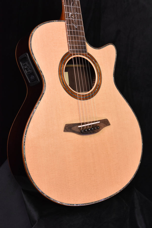 Acoustic cutaway guitar with light wood top, rosette ring, and bridge with strings