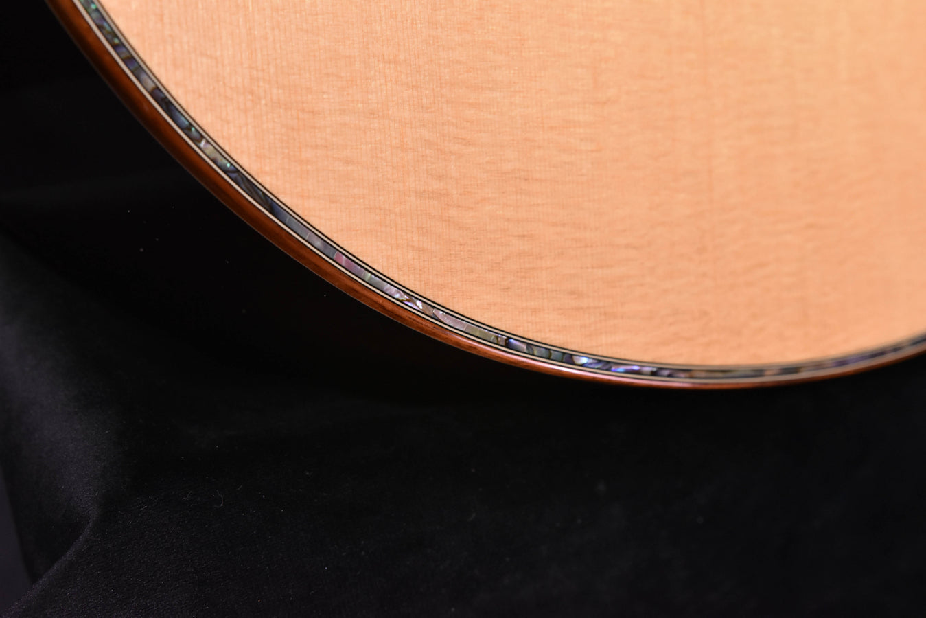 Guitar body edge close-up with decorative binding around the soundboard