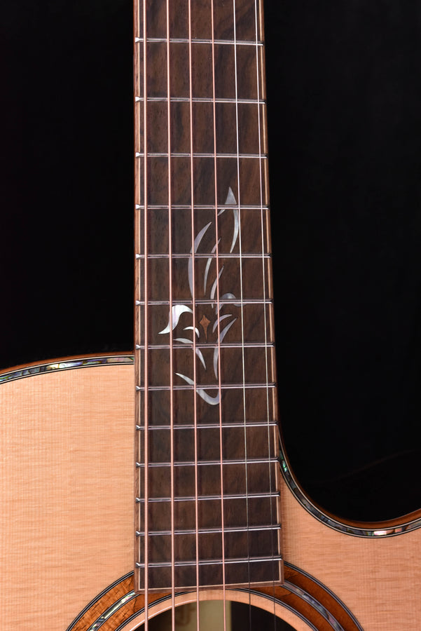 Fretboard inlay on acoustic cutaway guitar with strings and upper neck area