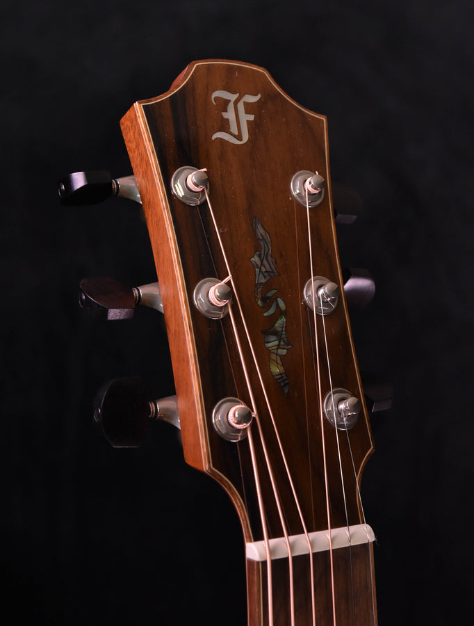 Guitar headstock with tuning pegs, nut, and decorative fretboard logo