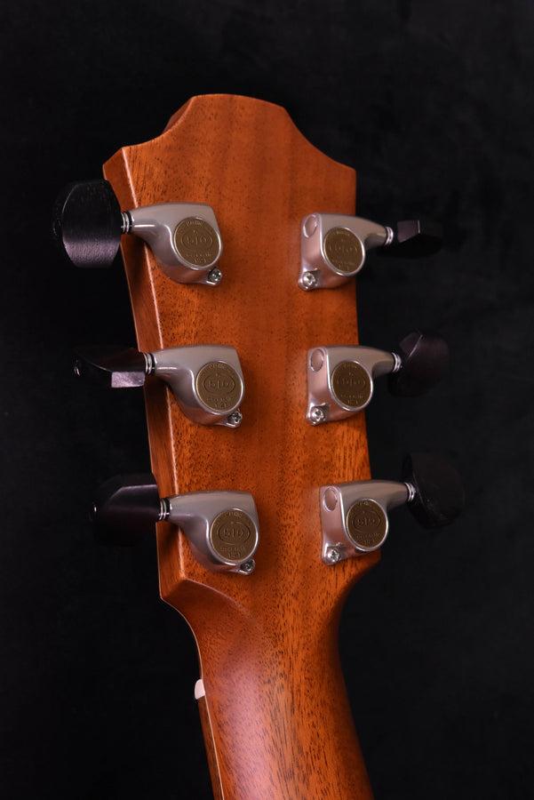 Close-up of headstock with six chrome tuning machines on red neck