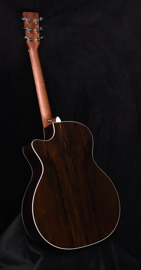Acoustic-electric guitar back view with white binding around dark wood body