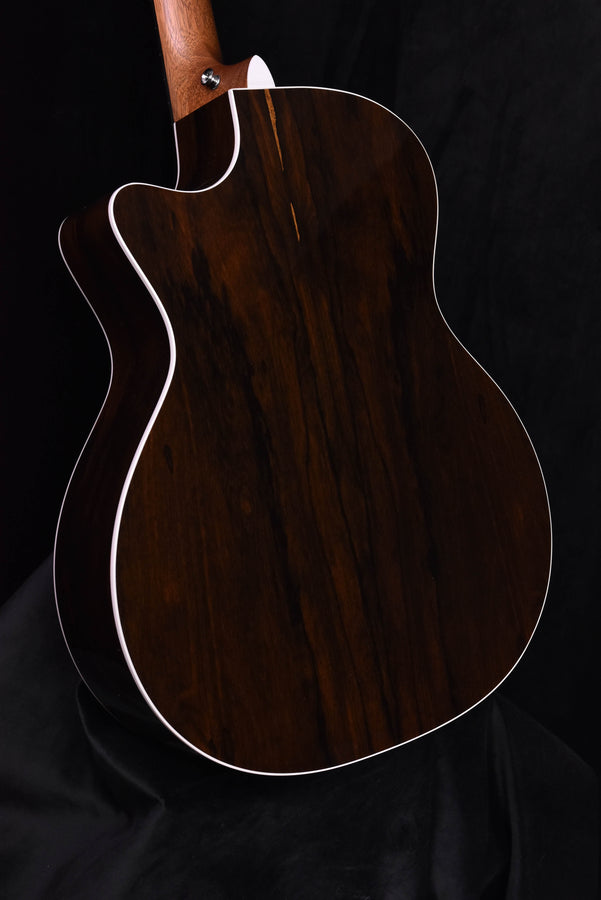 Acoustic-electric guitar side/back view, dark wood finish and white binding