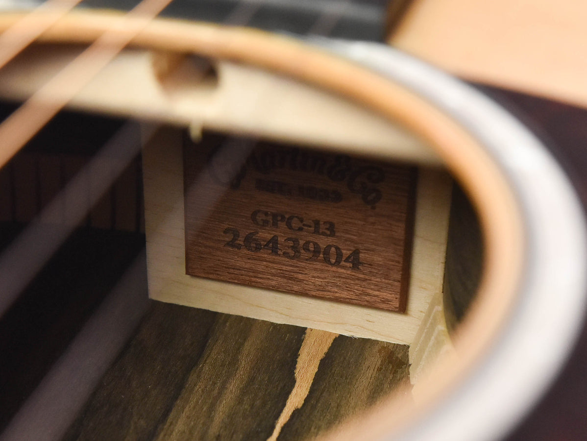 Guitar soundhole label close-up: 'GPC-13E 2643904' on dark plate