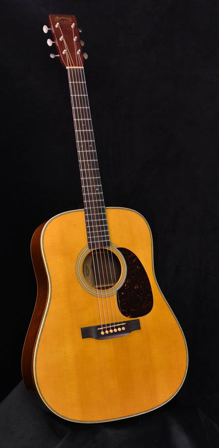 Martin-style dreadnought acoustic guitar with natural wood top and tortoiseshell pickguard