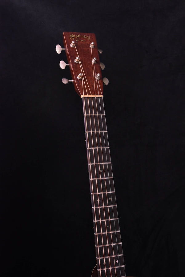 Acoustic guitar headstock with tuning machines and engraved brand on the dark wooden face