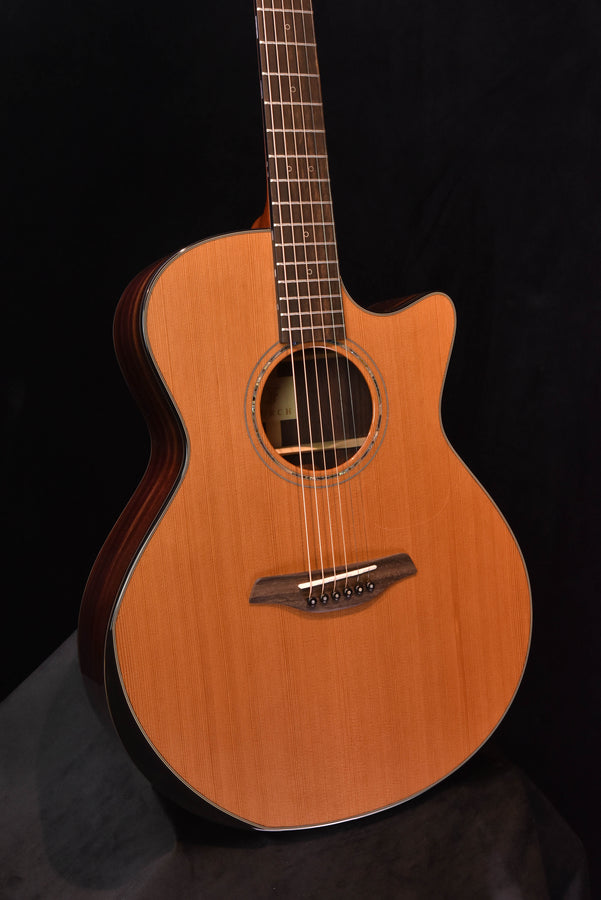 Front of yellow acoustic cutaway guitar, rosette and bridge with six tuning pegs