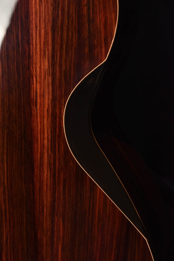 Close-up of guitar side and binding line on warm brown wood body