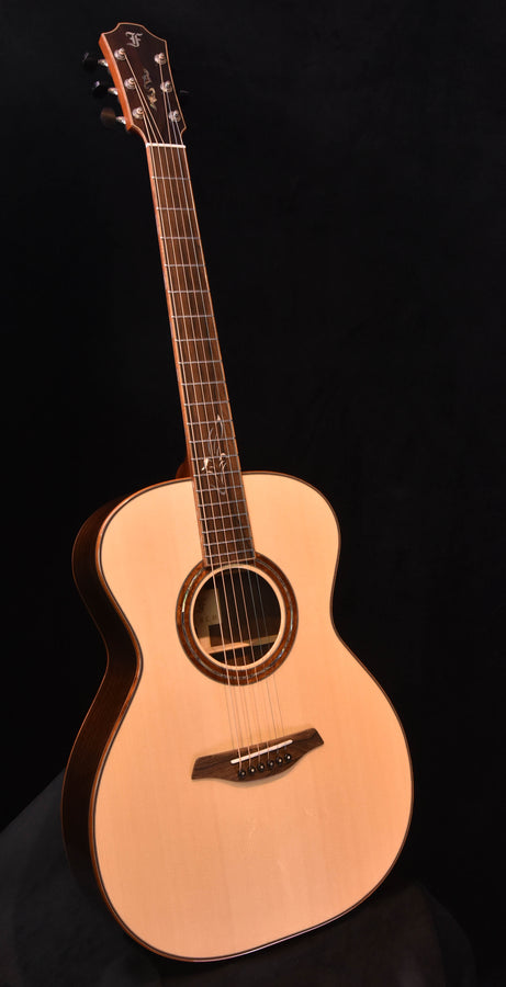 Used acoustic guitar with natural spruce top and dark rosette around the sound hole