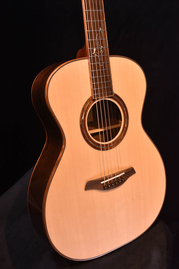 Front view of used acoustic guitar, natural top, f-shaped bridge area and rosette detail