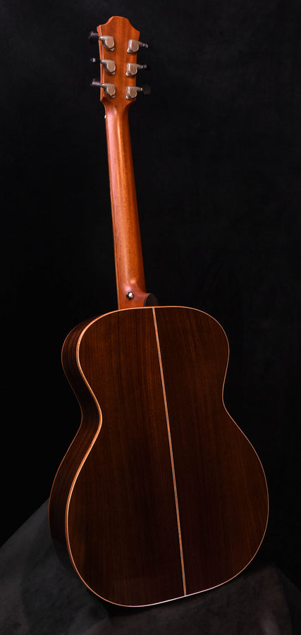 Used acoustic guitar back and neck view with dark wood finish and curved shoulders