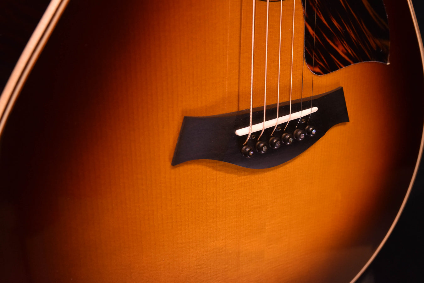 Tobacco sunburst bridge area with black pickguard, strings and saddle close-up