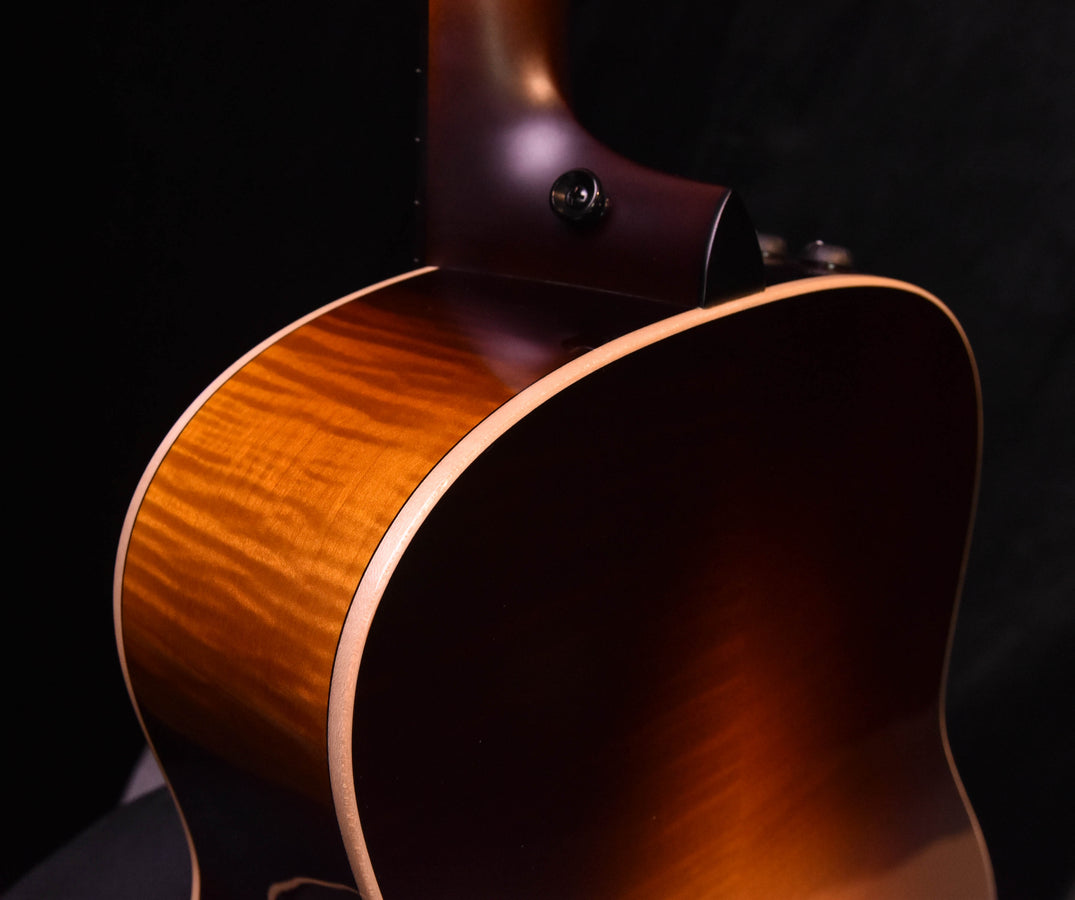 Tobacco sunburst grand auditorium guitar body close-up with cream binding