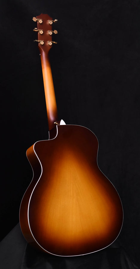 Acoustic-electric guitar back view, sunburst brown with white edge binding, tail section