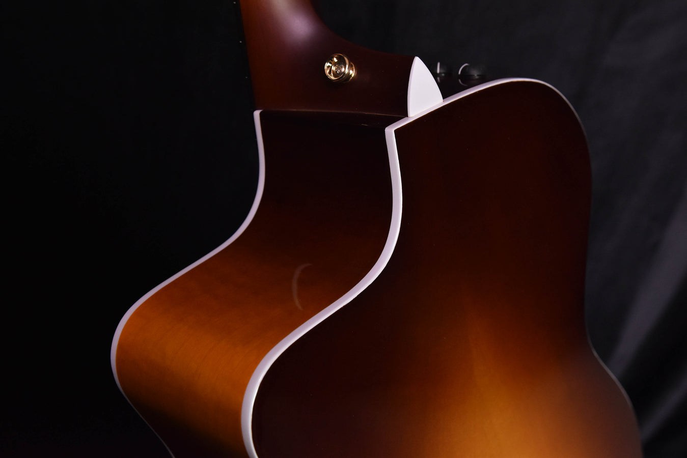 Acoustic-electric guitar cutaway side, sunburst body with white binding, close detail