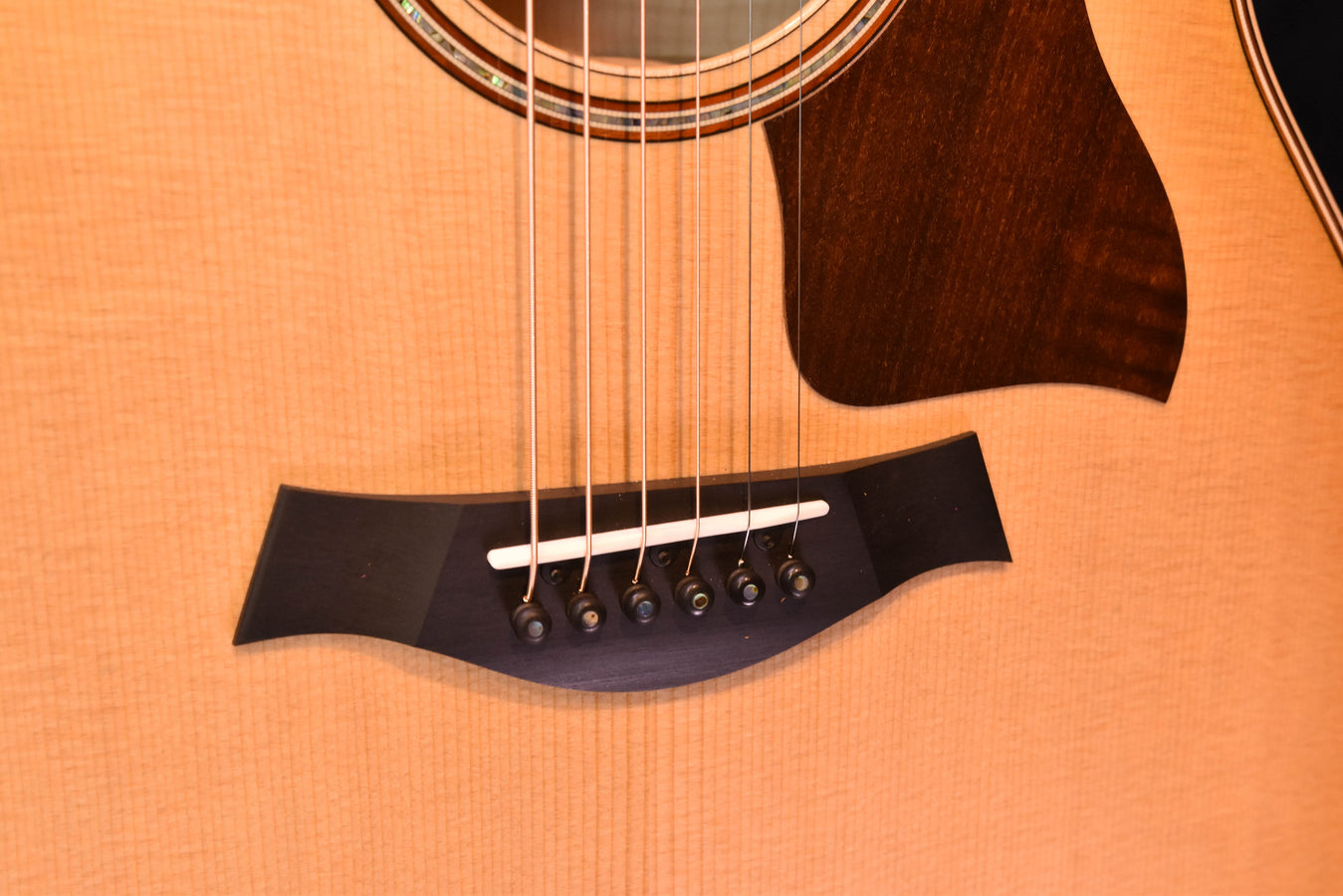Antique Blonde guitar bridge area with black pickguard and six strings