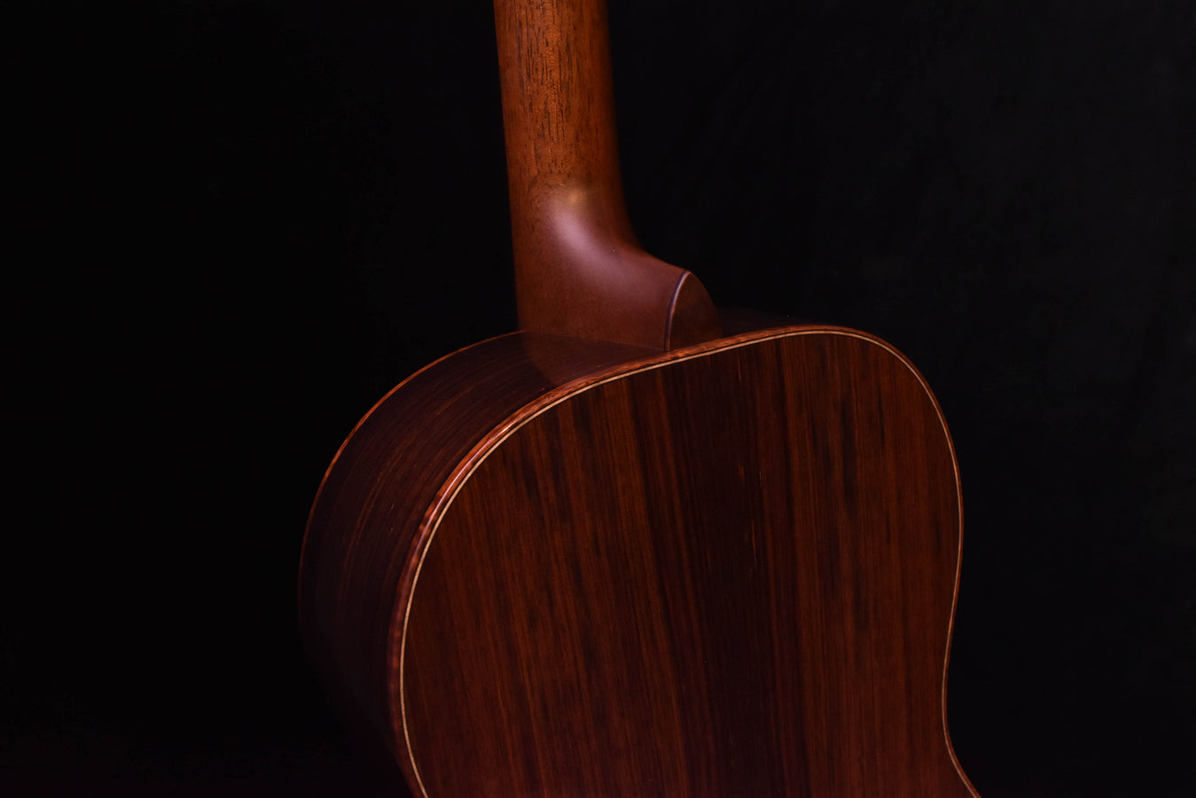Acoustic guitar back close-up with neck joint and wood grain texture
